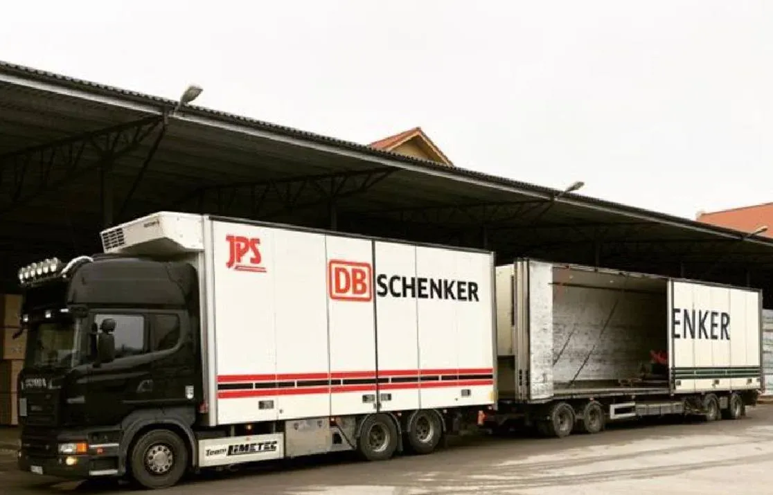 Scania med skåp backad mot lastkajen under skärmtak.